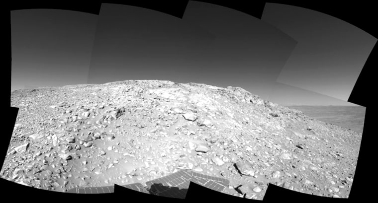 A rock outcrop with a view of the surrounding landscape beckons the Spirit rover in an image captured July 29. The picture was taken by the rover's navigation camera at a position labeled as Site 80, near the top of the "West Spur" portion of the Columbia Hills.