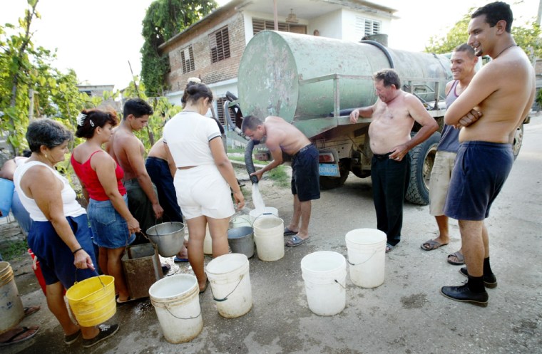 Residents of Holguin city, about 435 miles east of Havana, line up to get water from a truck on Wednesday July 28, 2004 in Cuba. Holguin and other eastern areas of Cuba are suffering the worst drought in the region in 40 years. (AP Photo/Cristobal Herrera)