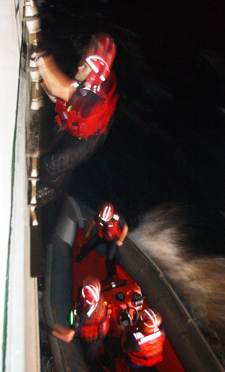 US Coast Guard climb up the side of a merchant ship during a boarding exercise to search for a known terrorist that was being stowed away on board as part of the joint-operation 'Panamax 2004', a simulated attack on the Panama Canal, in the Caribbean Friday, August 13, 2004. Colombia, the US, Chile, Argentina, Honduras, Panama, Dominican Republic, Peru, the Dominica and Ecuador are participating in the week-long training operation. (AP Photo/Kathryn Cook)