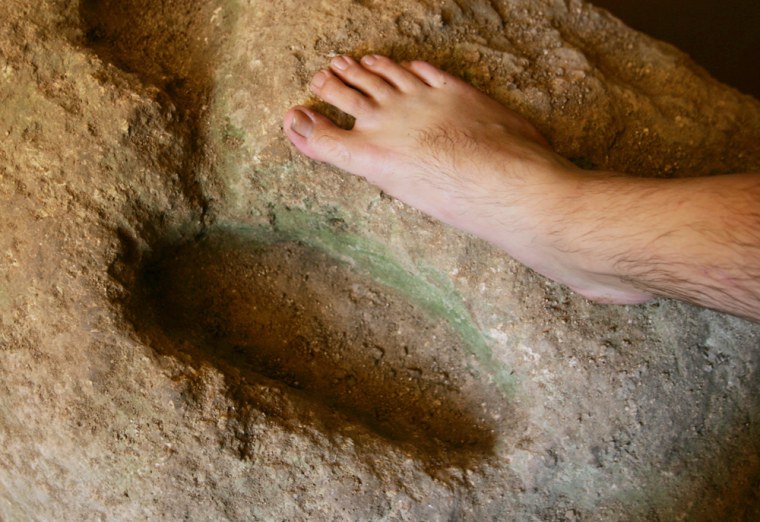 Israeli archaeological site manager Rafi Lewis places his foot on a stone the excavation team believes was used for ceremonial foot washing in a cave where the excavation team believes John the Baptist annointed many of his disciples, on the Kibbutz Tzuba, near Jerusalem, Monday, Aug. 16, 2004. The cave is a huge cistern with 28 steps leading to an underground pool of water. (AP Photo/Kevin Frayer)