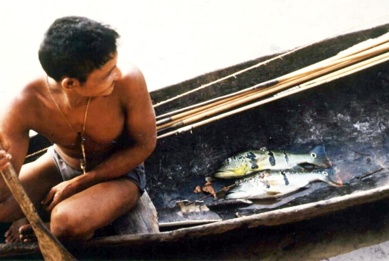 A Piraha tribesman returns from a fishing trip.