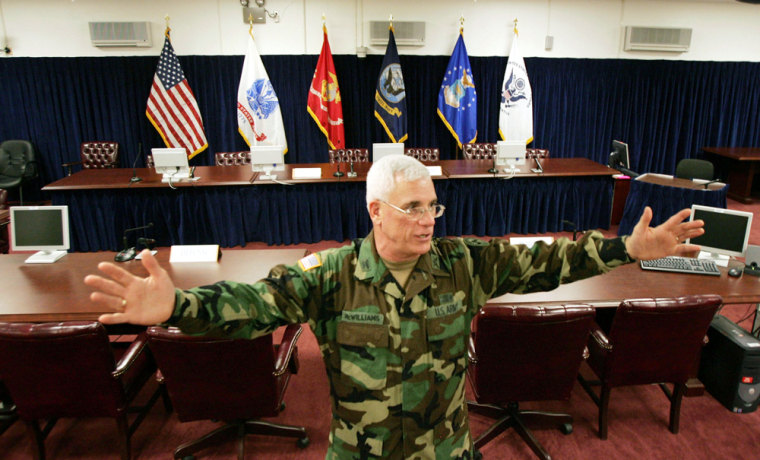 U.S. Army Col. David McWilliams gives the news media a tour of the courtroom where preliminary hearings will be held this week for four detainees held on the Naval Base.