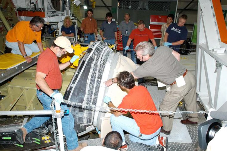 Workers check the shuttle Atlantis' nose cap after its installation this week in the Orbiter Processing Facility at NASA's Kennedy Space Center. Atlantis is due to be on standby during Discovery's launch next year.