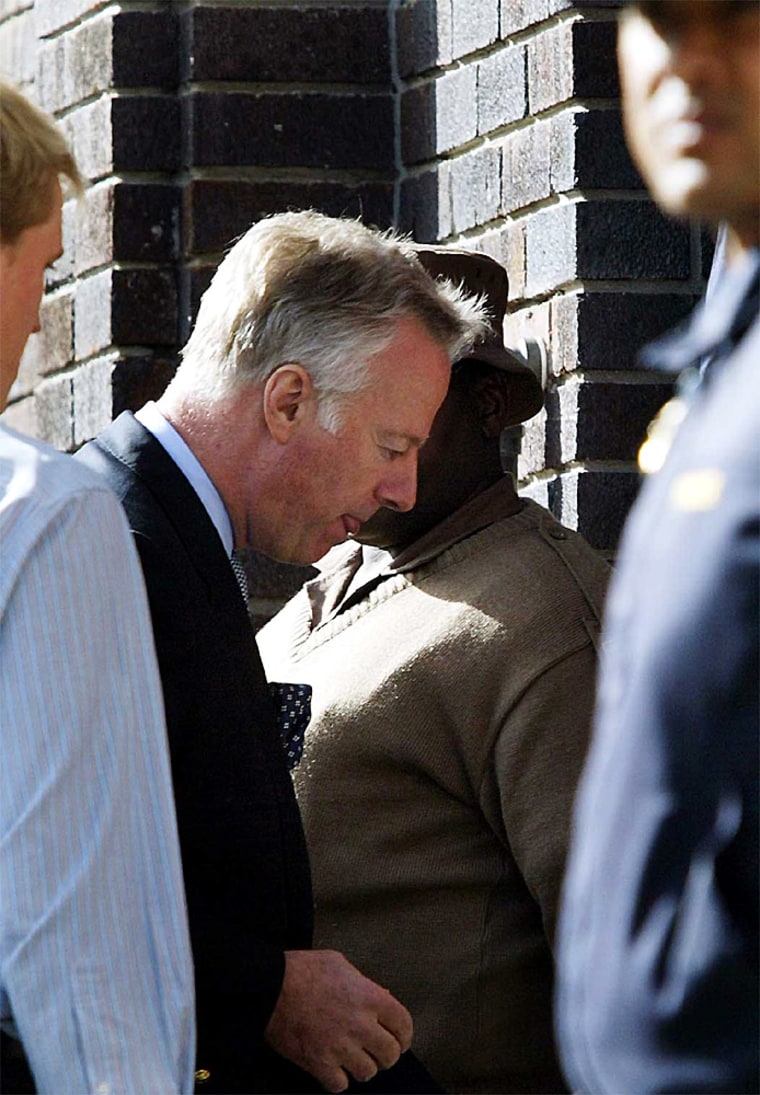 Mark Thatcher son of former British Prime Minister Margaret Thatcher is escorted into Wynberg Magistrate's Court in Cape Town