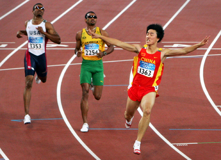 China's Liu Xiang celebrates as he crosses the finish line to win the men's 110 metres hurdle final at the Athens 2004 Olympic Games