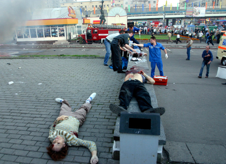** EDS NOTE: GRAPHIC CONTENT ** Bodies of victims of an explosion are seen outside the Rizhskaya subway station in Moscow, Tuesday, Aug. 31, 2004. A car blew up outside a busy subway station in Moscow Tuesday and news reports said eight people were killed and 18 injured. (AP Photo/Dmitry Shalganov)