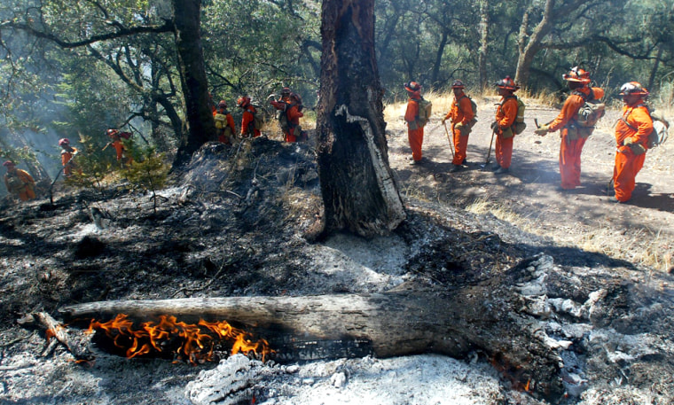 A California Corrections crew on Monday clears brush from a fire in Sonoma County. The fire is one of only a few burning in the West, making it hard for seasonal fire crews to get work.