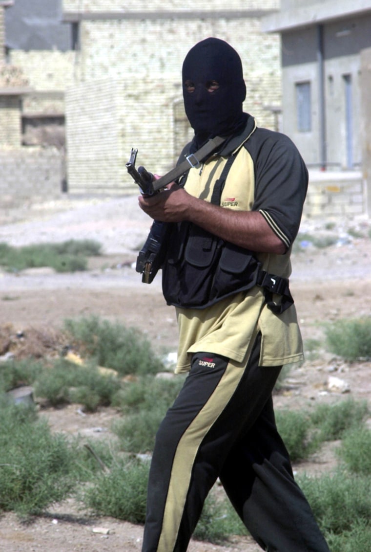 A masked insurgent patrols Fallujah, Iraq, Wednesday, Sept. 8, 2004. On Tuesday night and Wednesday morning, U.S. jets fired several missiles into Fallujah in retaliation for Monday's militant attacks on Marine positions outside the city that killed seven Marines. (AP Photo / Abdul Khader Sadi)