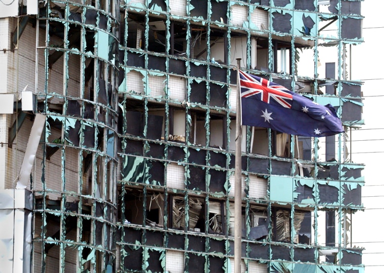 An Australian flag flies near a damaged building, following a blast outside the Australian Embassy, Thursday, Sept. 9, 2004, in Jakarta, Indonesia.  At least three people were killed and more than 50 were wounded. (AP Photo/Achmad Ibrahim)