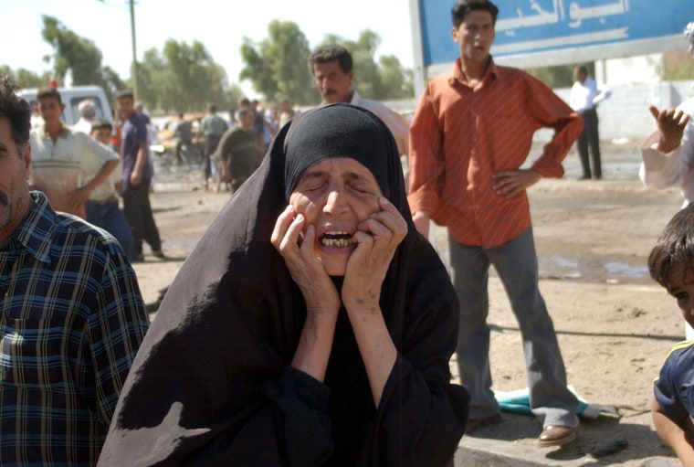 An unidentified woman cries after identifying a pair of shoes lying at the site of a massive explosion outside a police station in Haifa street, Baghdad, Iraq, those of her son Tuesday Sept. 14, 2004. At least 32 people were killed and 88 wounded as the blast ripped through scores of people gathered there hoping to join the police force. (AP Photo/Khalid Mohammed)