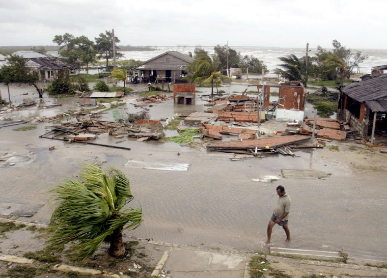 Cuban walking on flooded street past damaged houses after Hurricane Ivan brushes Cuba