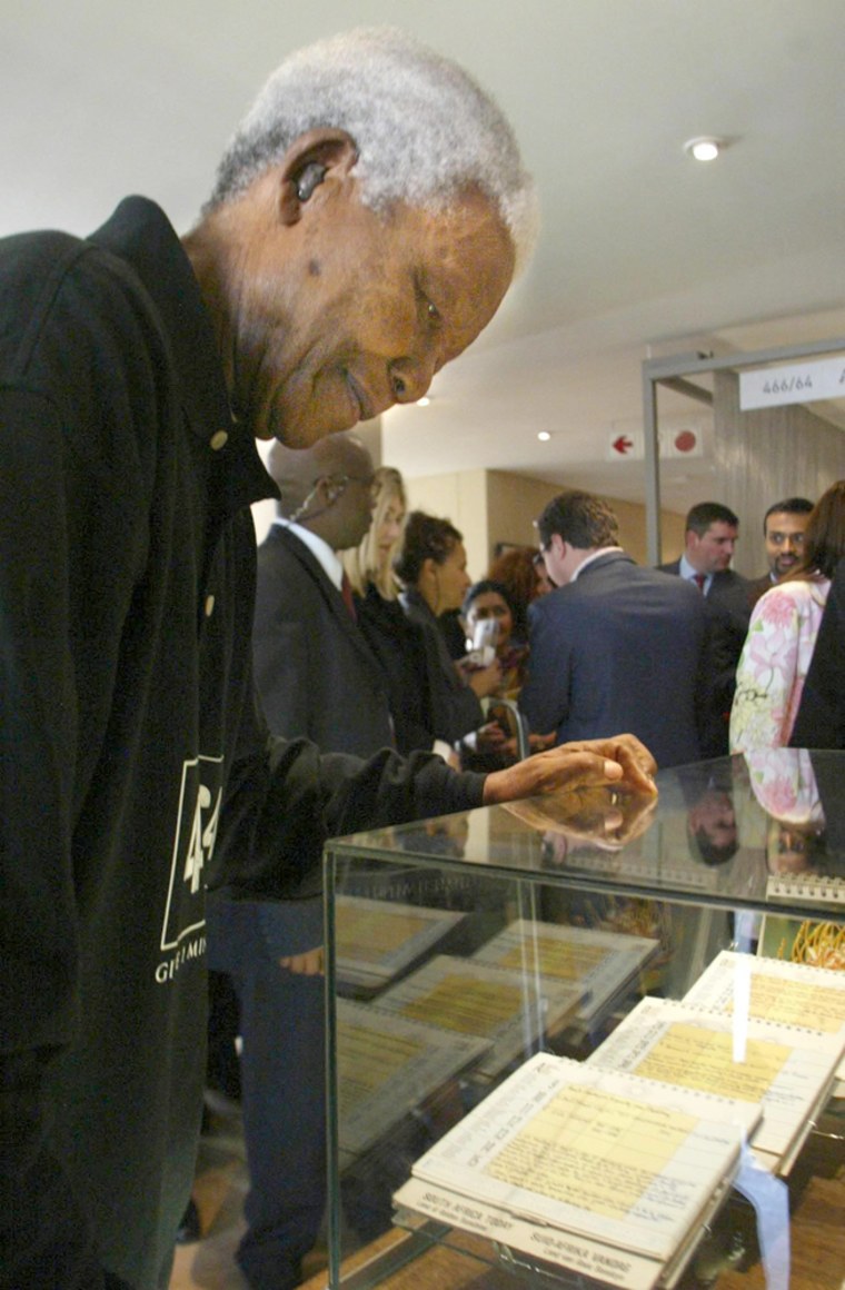 Former South African President Nelson Mandela examines Tuesday some of the personal letters he wrote at Robben Island prison more than 30 years ago, during the opening of the Nelson Mandela Center for Memory and Commemoration in Johannesburg.