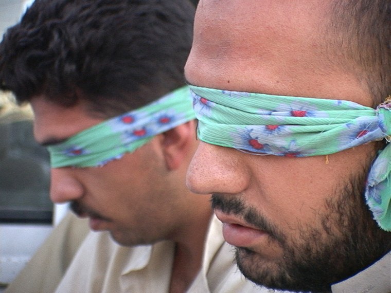 Two Iraqis detained by the Hilla Special Weapons and Tactics (SWAT) team - the elite Iraqi police force during a raid in Jabella, Iraq.