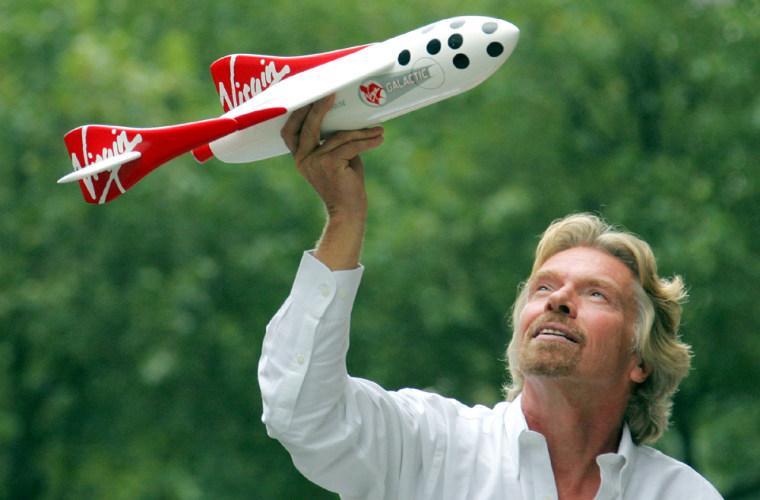 Sir Richard Branson holds model of a spacecraft at a news conference in central London