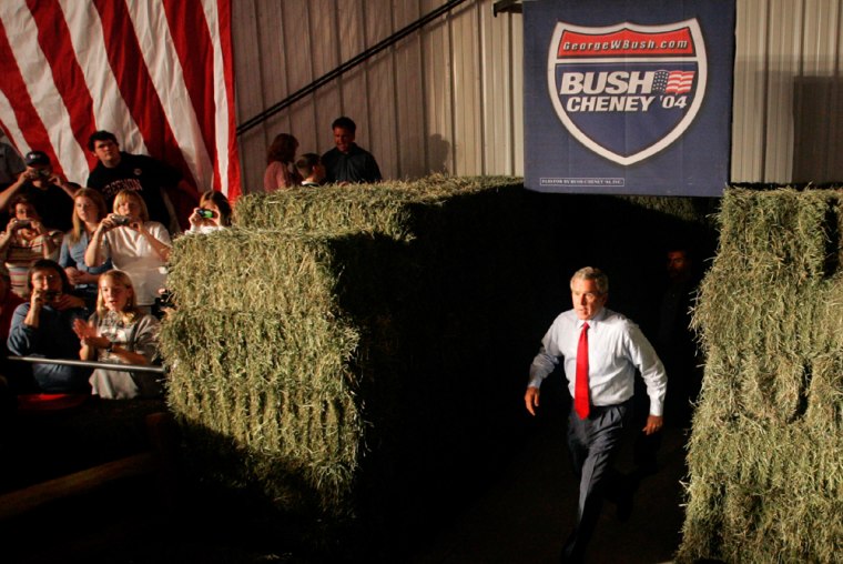 U.S. President George W. Bush walks between hay bales enters a campaign event in Ohio