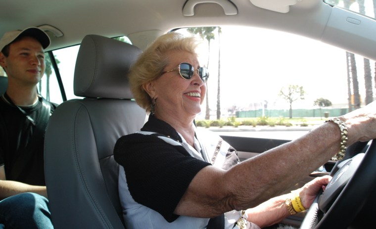 Elsie Horspool of Los Alamitos, Calif., made a special trip to Long Beach, Calif., to test drive the fuel cell cars. Here she tries VW's HyMotion as VW engineer Soren Stobbe watches from behind. 