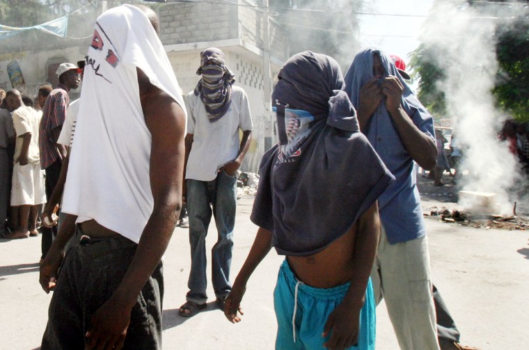 Supporters of former President Jean-Bertand Aristide hold a small prostest in the pro-Aristide slum of Bel-Air, in Port-au-Prince, on Monday, Oct. 4,2004. Now in exile in South Africa, Aristide has accused U.S. agents of kidnapping him and forcing him out of the Caribbean country on Feb. 29 amid a bloody rebellion - a charge the U.S. government denies. (AP Photo/Ariana Cubillos)