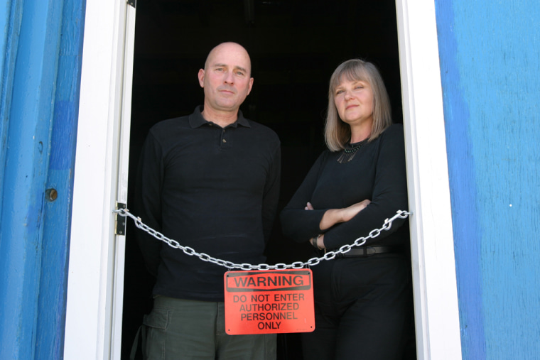 Rod and Randa Milliron of Interorbital Systems stand at the entry to their hangar at the Mojave Airport in Mojave, Calif. The Millirons had been working on a suborbital rocket for the Ansari X Prize, but now they're focusing on orbital launch vehicles.