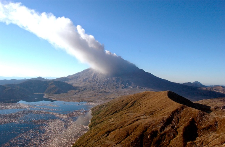 Mount St. Helens exhales a cloud of steam and ash on Tuesday, in this aerial view showing Spirit Lake in the foreground. Scientists say today's tools provide much better data than volcanologists had at their disposal when the mountain blew in 1980.