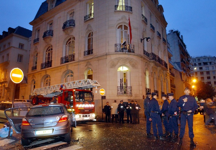 Police officers and rescuers stand outside the Indonesian Embassy in Paris early Friday after a small bomb exploded there.
