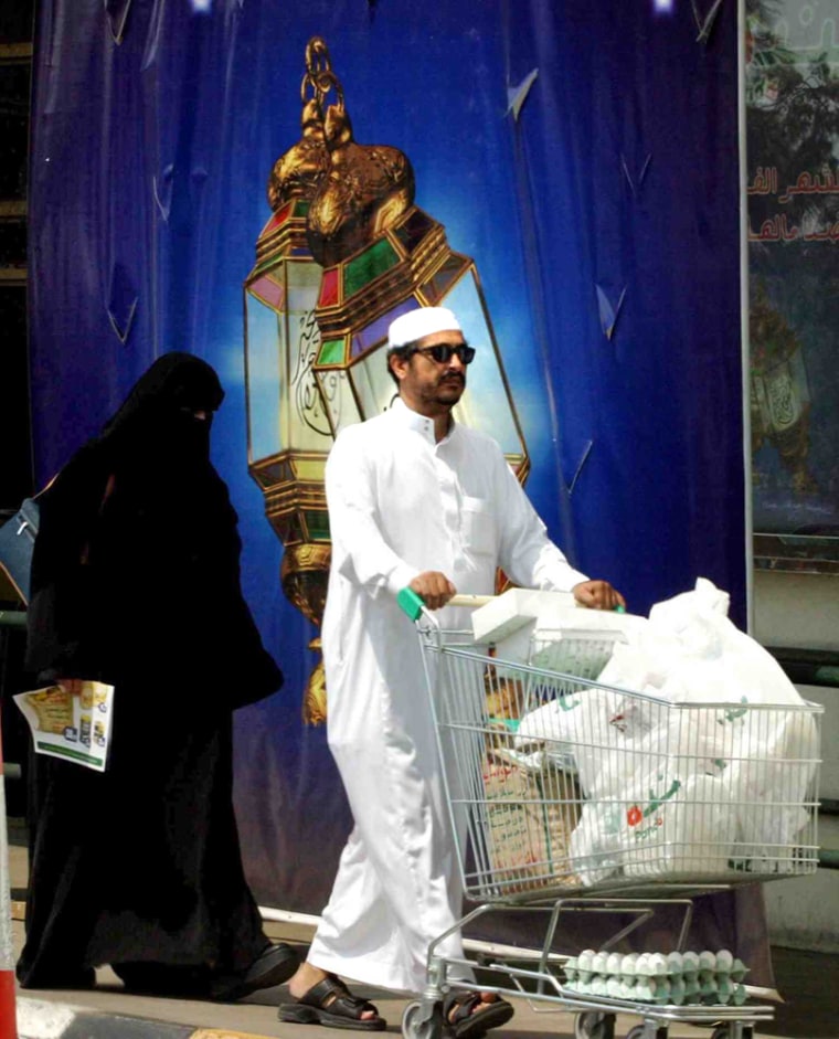 A Saudi family walks after shopping Monday in Jeddah, Saudi Arabia. Women can neither run nor vote in Saudi Arabia's first nationwide municipal elections next year, officials said Monday.
