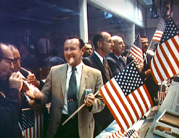 NASA spacecraft designer Max Faget is the cigar-smoker at far left in this photo, taken at Mission Control in Houston after Apollo 11's splashdown in 1969. Other officials include, to the right of Faget, George Trimble, Chris Kraft, Julian Scheer, George Low, Robert Gilruth and Charles Mathews.