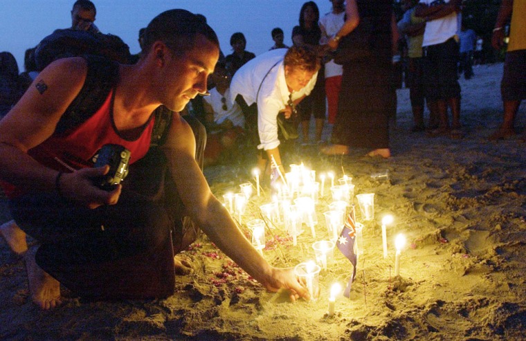 People place candles in the sand during a Tuesday ceremony to remember the 202 victims of the Bali bombings on the event's second anniversary in Bali, Indonesia. 