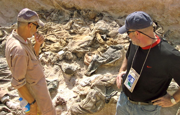 Archaeologist Trimble and lawyer Kehoe view a mass grave site being excavated in Hatra