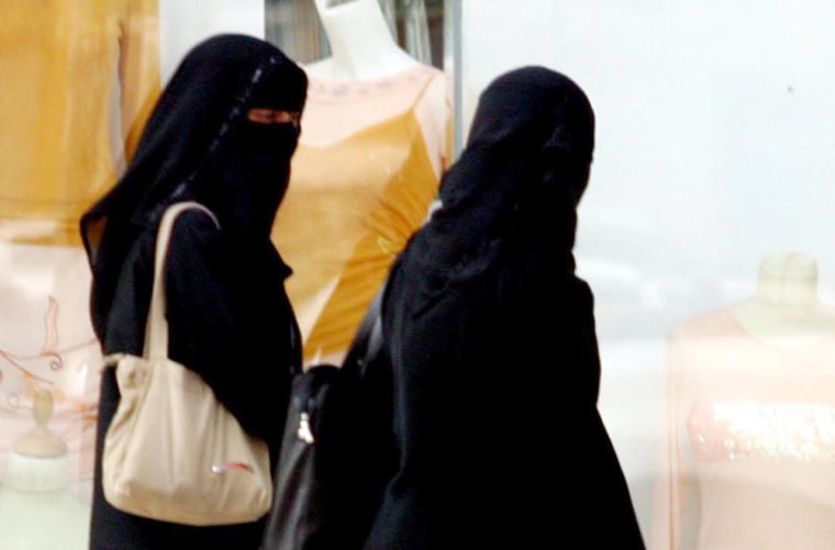 Two Saudi women walk Tuesday along a street in Riyadh, Saudi Arabia. Women may neither vote nor run in Saudi Arabia's first nationwide elections, the government announced Monday. 