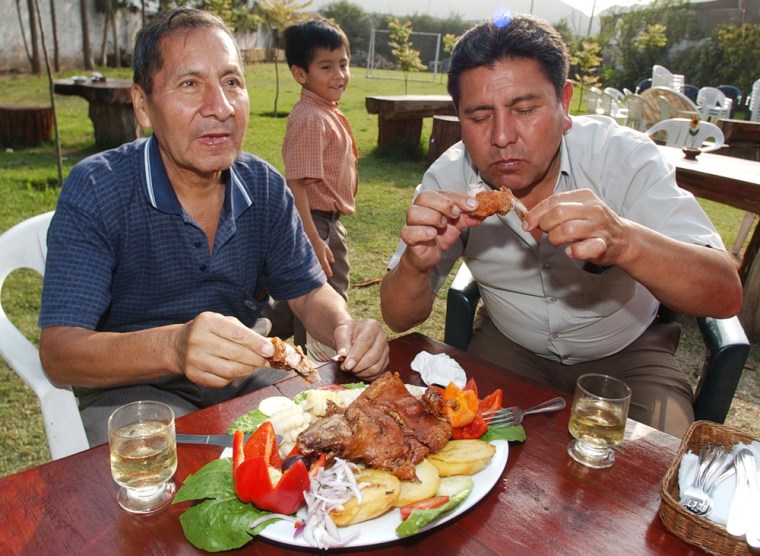 Segundo Quispe (left) and his nephew Maximo Quispe eat guinea pig in a restaurant in Lima, Peru on Oct. 18. Peruvians consume an estimated 65 million guinea pigs each year.