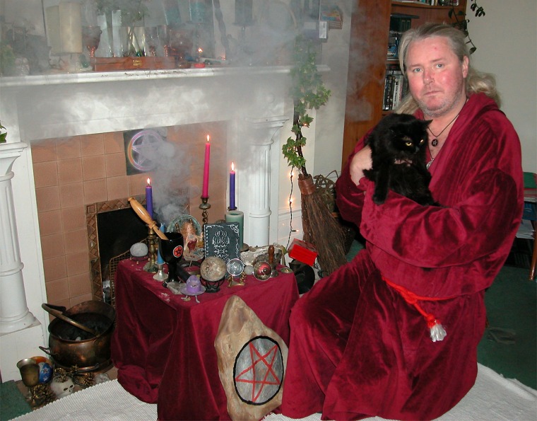 Kevin Carlyon, a high priest of British white witches, holds one of his 10 black cats at his home in St. Leonards, Sussex.
