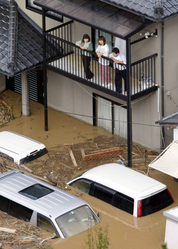 Isolated residents in Toyooka, western Japan wait to be rescued Thursday, Oct. 21, 2004. Typhoon Tokage unleashed flash floods that washed away entire hillsides, killing at least 31 people and leaving about 40 people missing before it veered east into the Pacific Ocean on Thursday. (AP Photo/Kyodo News) ** JAPAN OUT NO SALES MANDATORY CREDIT **
