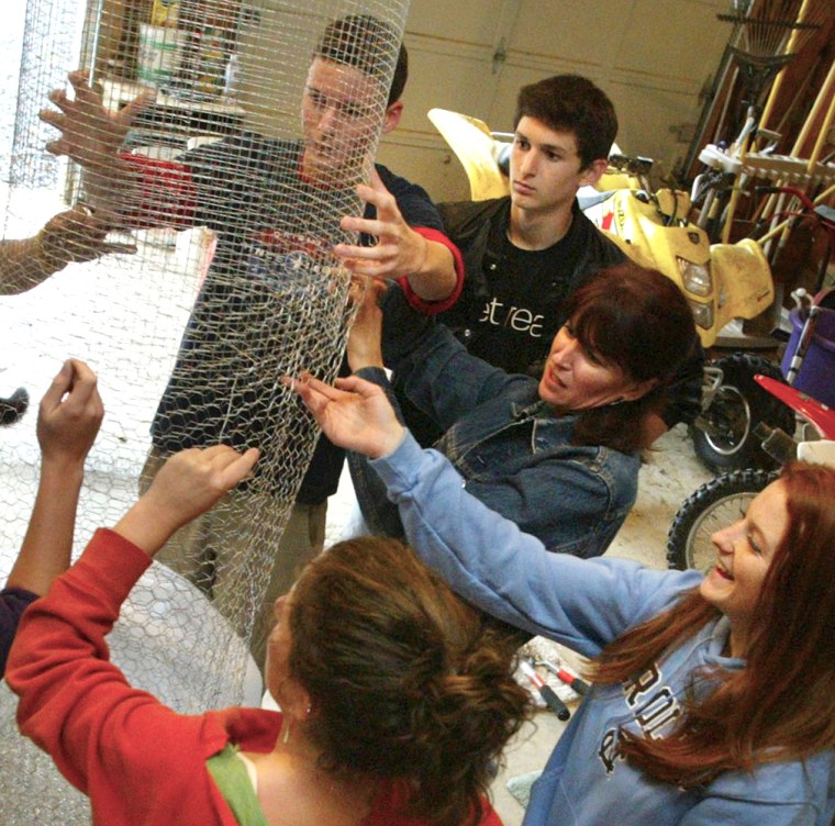 Students at Loudoun Valley High School in Purcellville, Va., work on their class float in a garage.