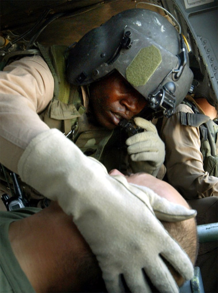 U.S. Army Medic Ssg. Tyrone Jordan examines a sick American soldier during a helicopter evacuation from the countryside near Iskandariyah south of Baghdad, Iraq Wednesday, Oct. 20, 2004.  Members of the U.S. Army's 45th Medical Company based in Babylon, evacuate wounded soldiers 24 hours a day from areas south of Baghdad and fly them for treatment at the main American hospital in Baghdad's Green Zone.(AP Photo/John Moore)