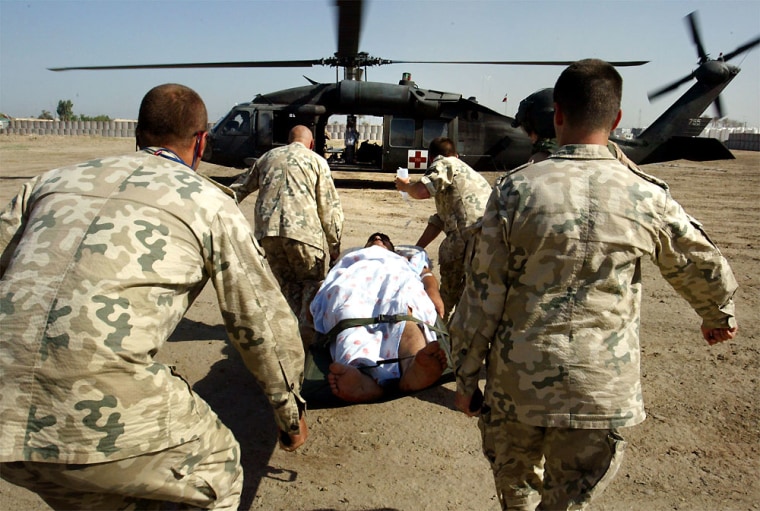 Polish soldiers carry an Iraqi national guardsman with a gunshot wound to the stomach for helicopter evacuation by the U.S. Army's 45th medical company on Wednesday.