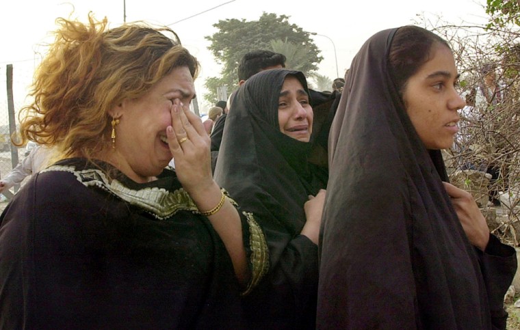 Iraqi women cry at the spot where a bomb exploded Monday, Oct. 25, 2004 near a U.S. military convoy in central Baghdad, Iraq, killing at least three people and injuring several, the Iraqi Interior Ministry said. The bomb was targeting the U.S. convoy when it detonated in the Karrada neighborhood of Baghdad. (AP Photo/Hadi Mizban)