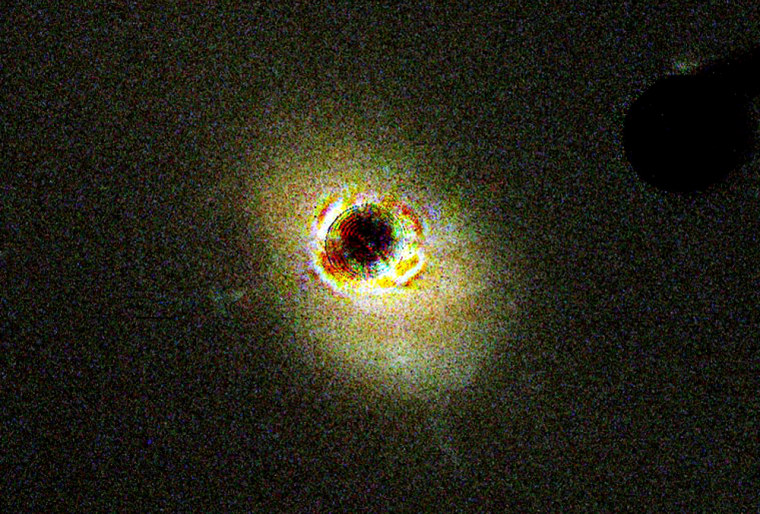 The nearby quasar 3C 273 is seen in a Hubble photo released in 2003 that reveals internal details, with light from the central bright portion of the quasar blocked.