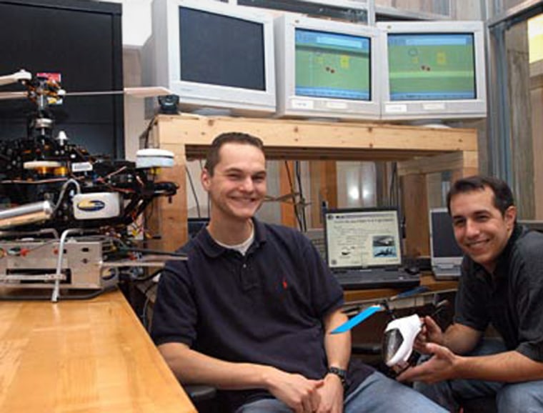 Graduate students Tom Schouwenaars, left, and Mario Valenti sit in front of the operational guidance system they worked on which is being used to fly an unmanned aircraft from a manned parent plane to gain surveillance in dangerous situations.