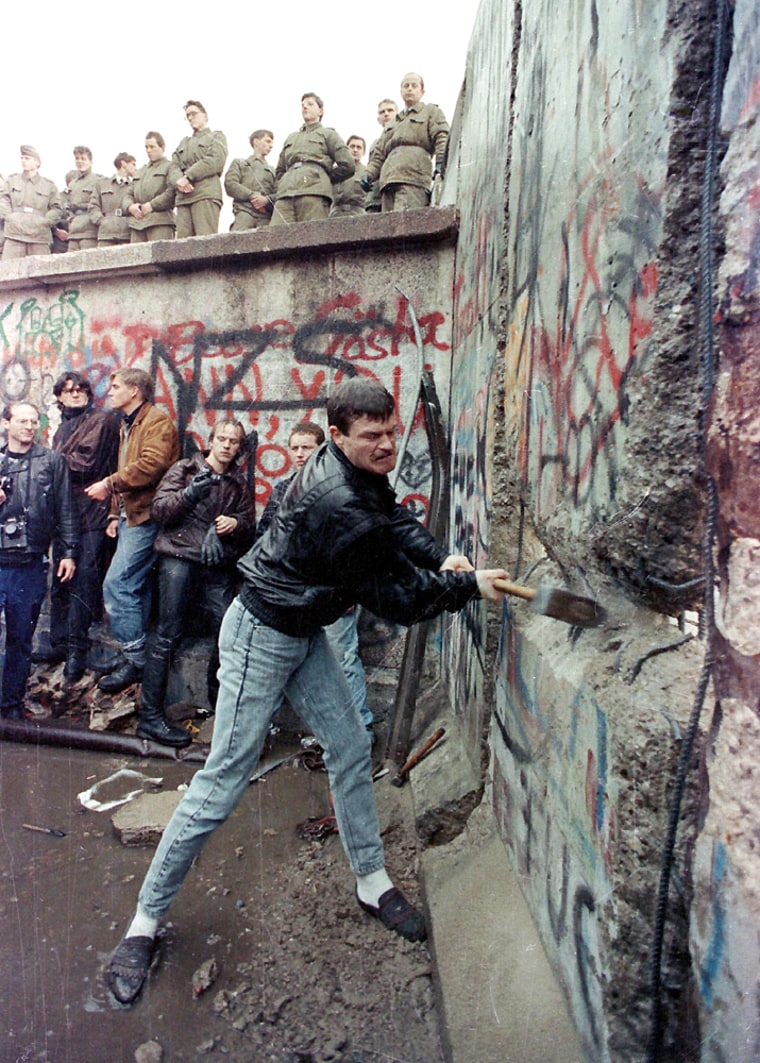 File photo shows a demonstrator breaking the Berlin Wall