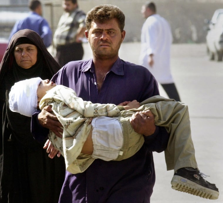 An Iraqi man carries a wounded child from the emergency room to another section of Al-Kindi hospital in Baghdad, Iraq, Thursday Nov. 11, 2004, after a huge explosion in a densely populated commercial area in the center of the capital. The child was familiar to police for selling newspapers in the area. (AP Photo/Karim Kadim)