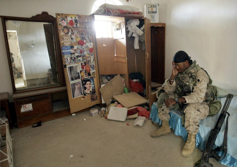 A U.S. Marine rests on a bed after searching a house in the western part of Fallujah on Saturday.
