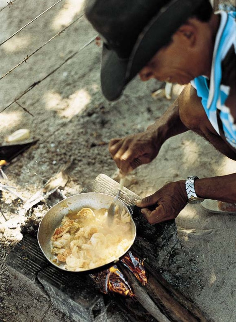 A fisherman sauteing fresh lobster chunks on the beach on Ilha de Boipeba