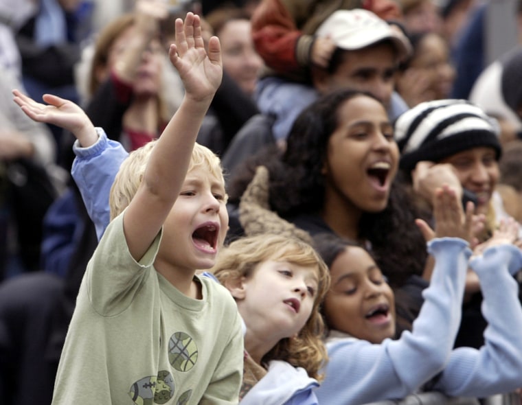 Nicoli Sysyn, left, of Minnesota, waves at Santa Claus during the Macy's Parade in New York Thursday, Nov. 25, 2004. The parade, featuring 59 balloons and 27 floats, stepped off just after 9 a.m. and began its procession toward Herald Square in Manhattan. (AP Photo/Gregory Bull)