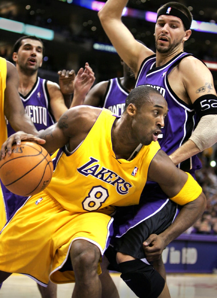 Los Angeles Lakers Kobe Bryant drives past Sacramento Kings Miller and Stojakovic in Los Angeles