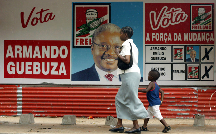 A mother and her child walk past a campaign poster showing Armando Guebuza, presidential candidate for the ruling Frelimo party, a day before the elections in Maputo, Mozambique, Tuesday, Nov. 30, 2004. Mozambique is holding parliamentary and presidential elections Dec. 1 and 2. (AP Photo/STR)