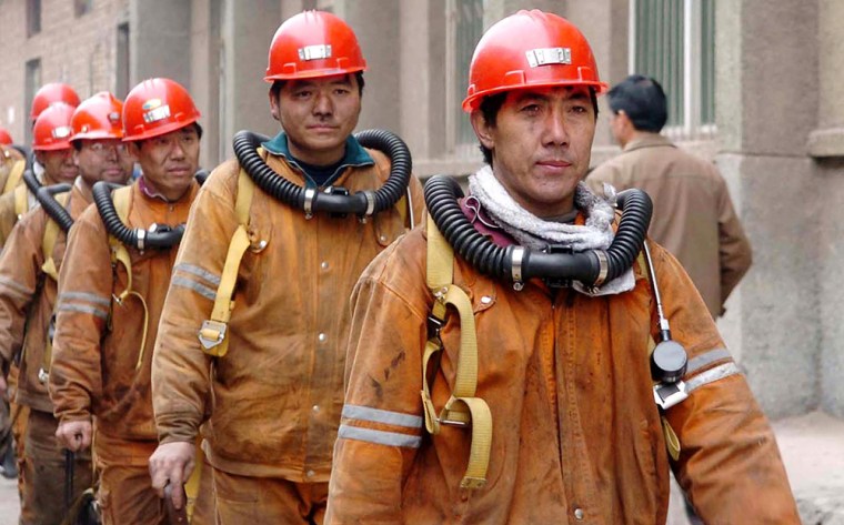 Chinese rescuers emerge from the underground tunnel in Chenjiashan