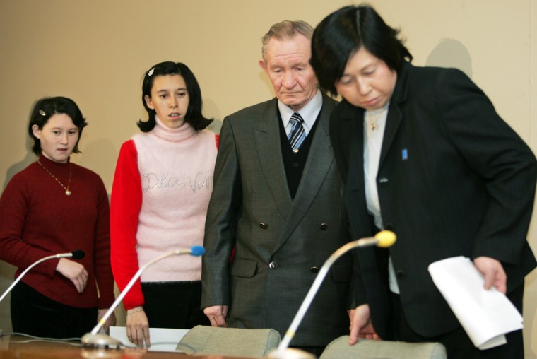 Former abductee Hitomi Soga leads U.S. Army deserter Charles Jenkins and daughters into news conference room in Sado, Japan
