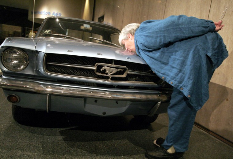 Retired Smithsonian conservator Eleanor McMillan kisses her 1965 Ford Mustang hardtop coupe after donating it to the museum.