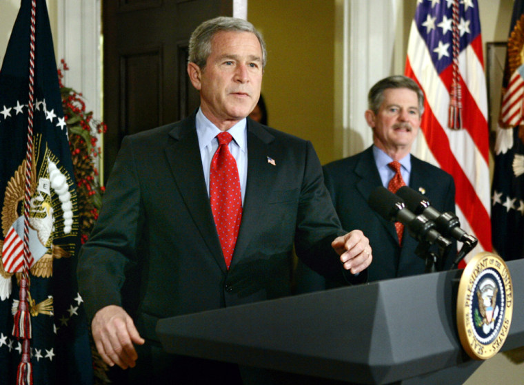 U.S. President George W. Bush walks into the Roosevelt Room with Jim Nicholson in Washington