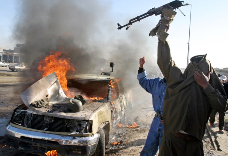 Iraqi man chants near burning vehicle in Mosul